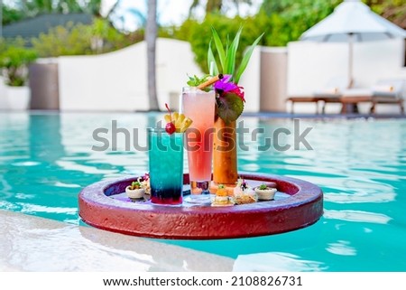 served floating tray in swimming pool with drinks and snacks on tropical island resort in Maldives, cocktails and canapes for romantic date or honeymoon in luxury hotel, travel concept Royalty-Free Stock Photo #2108826731