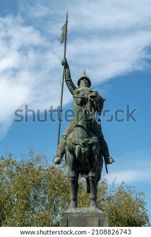 A shot of a statue of soldier over his horse and rising a flag