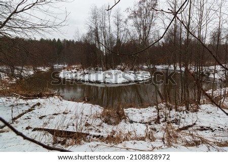river bend in winter with gloomy sky