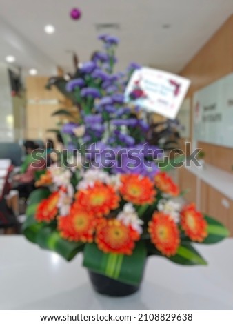 A picture of a purple and orange flower bouquet. Abstract defocused blurry background