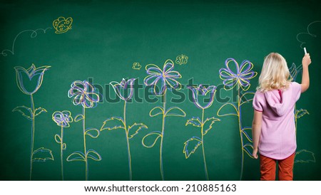 little girl drawing flowers on a wall