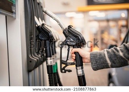 Closeup of woman pumping gasoline fuel in car at gas station. Petrol or gasoline being pumped into a motor. Transport concept Royalty-Free Stock Photo #2108877863