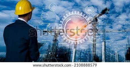 Double exposure of businessman hands using tablet and technology global networking security information with innovation icon virtual screen, Digital and construction cranes blurred background.