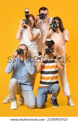 Group of photographers on color background Royalty-Free Stock Photo #2108905925