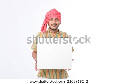 Young indian farmer holding white card board on white background.