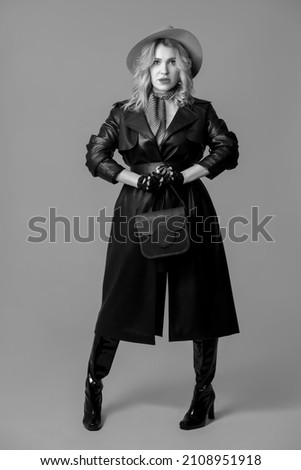 Stylish fashion model. Black and white photo. Half-length monochrome portrait of young beautiful woman posing isolated on gray studio background. Beauty, fashion, style, bodypositive concept