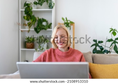 Smiling young woman using laptop at home, looking at screen, chatting, having video conference . business trainer tutoring by webcam, online training, e-coaching concept