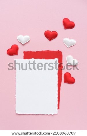 Empty white sheet of paper and decorative hearts on a pink background. Flat lay, place for text. vertical image