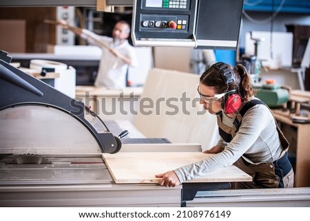 male and female carpenter at work, man and woman are crafting with wood in a workshop, two craftsmen or handymen working with carpenter tools or electric machines Royalty-Free Stock Photo #2108976149