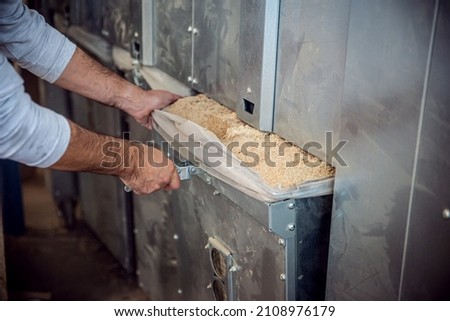 a carpenter empties the containers of an extractor or exhaust system, bags full of sawdust are emptied Royalty-Free Stock Photo #2108976179