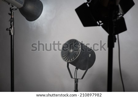 Three projectors standing enveloped in smoke. Isolated on grey background