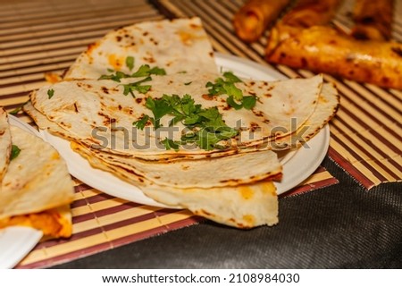 Mexican corn tortillas with cilantro on top, selective approach, gastronomy of Mexico.