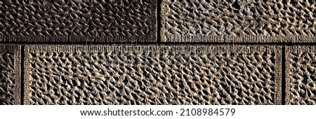 Wall with decorative imitation of stone blocks. Rough surface, painted in brown color. Wide panoramic texture for background and design.