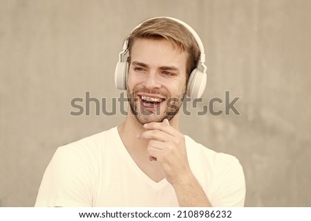 Noise Reduction. Wireless Earpiece. Handsome guy wear headphones grey background. Man listen modern music. Modern technology. Modern and contemporary music. Hobby leisure. Foldable Stereo Headphones
