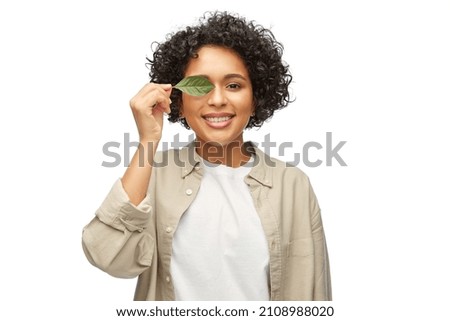 eco living, environment and sustainability concept - portrait of happy smiling woman holding green leaf over white background