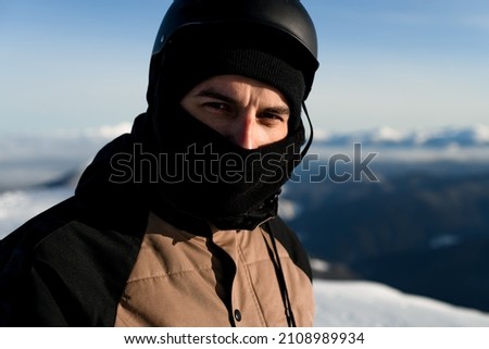 portrait of man in black balaclava and a ski helmet on his head. Looking at the camera Royalty-Free Stock Photo #2108989934