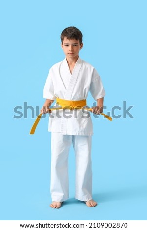 Little boy in karategi on color background Royalty-Free Stock Photo #2109002870