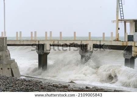 Storm waves on the Black Sea coast, Batumi, Georgia. Huge waves under the pier. Stormy weather.