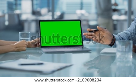Multiethnic Diverse Office Conference Room Meeting: Team of Two Creative Entrepreneurs Talk, Discuss Growth Strategy, Use Laptop with Green Screen Mock Up Display. Royalty-Free Stock Photo #2109008234