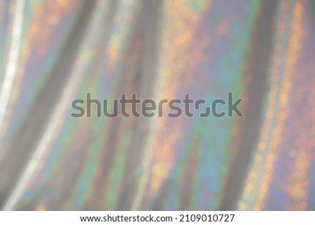 Abstract blurred background of holographic rainbow fabric