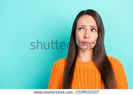 Photo of unsure mature brunette lady look promo wear orange sweater isolated on teal color background