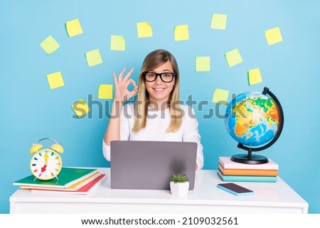 Portrait of attractive trendy cheerful confident skilled girl using laptop showing ok-sign isolated over bright blue color background
