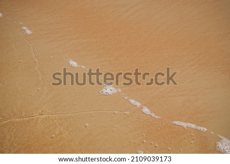 sandy seashore. quiet surf. a thin strip of surf