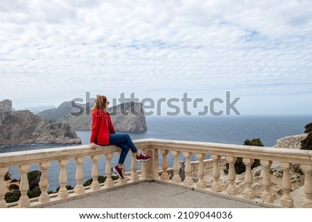 Beautiful woman in red hoodie on observation deck on Cape Formentor. Palma de Mallorca or Majorca, Balearic Islands, Spain
