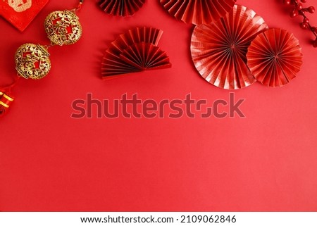 Chinese new year festival decoration with red bags and red folded fans on red background. Celebrate Happy Chinese new year background concept. top view. All Brushscript Texts in Chinese meaning luck.