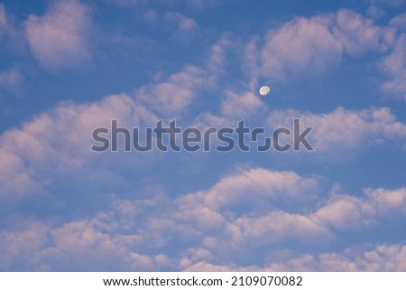 The moon in the blue sky among the clouds is like a background.