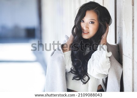 Beautiful woman outdoors. Pretty lady on urban background. Asian female closeup portrait.