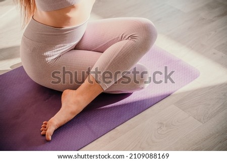 View from above. A beautiful young woman in pink sportswear is engaged in yoga, sports in the hall on a purple rug. Yoga, sport and healthy concept. Royalty-Free Stock Photo #2109088169