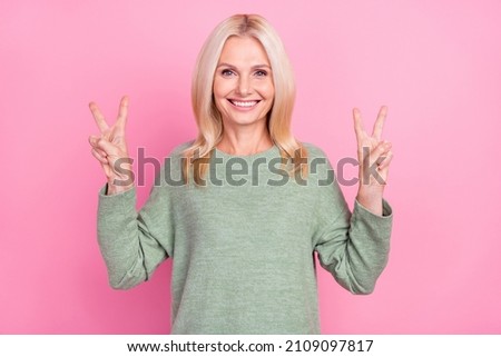 Photo of cute old blond lady show v-sign wear grey pullover isolated over pink color background