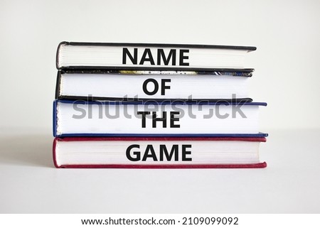 Name of the game symbol. Books with concept words 'Name of the game'. Businessman hand. Beautiful white background. Business and name of the game concept. Copy space.