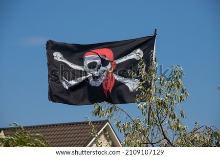 A skull and cross bones pirate flag waving in the wind.