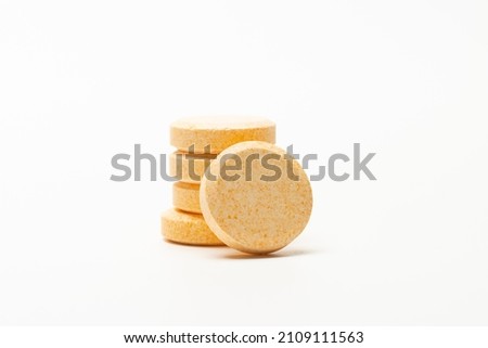 Image of orange soluble tablet or pills isolated on white background. This type of tablet can dissolve in water.  usually for vitamin, supplement or medicine. 