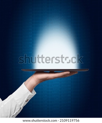 Businessman hand holding tablet computer with glowing interface. Innovation and cyberspace concept.
