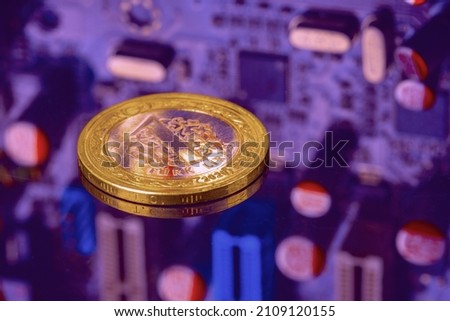 One Turkish Lira coin on CPU circuit board. Real money from Turkey. Online trading. Cross-national binary virtual payment system. Purple technology business motherboard background with copy space 