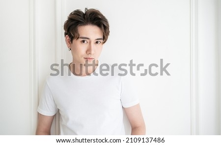 Attractive young handsome smiling face positive asian, korean happy casual man, stay home minimal lifestyle. Closeup portrait of asia middle age 20s man wearing white shirt in studio. Young model boy  Royalty-Free Stock Photo #2109137486