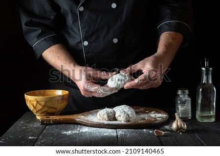 Cooking cutlets by the hands of a chef in the restaurant kitchen. The idea of making a delicious breakfast or lunch.
