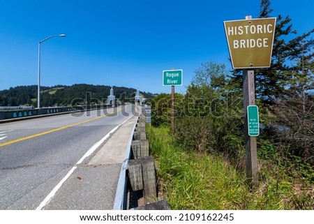 Signs and obelisks on the south end of the Rogue River Bridge in Gold Beach, Oregon, USA