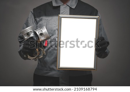 Car service worker diploma template. Best mechanic diploma mockup. Worker with a piston and blank photo frame in hands on the gray background. Front view.