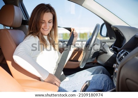 Safety first. Beautiful caucasian lady fastening car seat belt.  Royalty-Free Stock Photo #2109180974