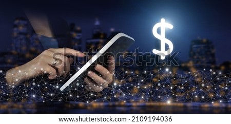Hand touch white tablet with digital hologram dollar sign on city dark blurred background. Investment business online concept Global currency exchange concept.