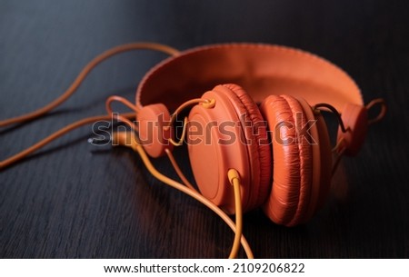 Modern orange headset headphones on the table