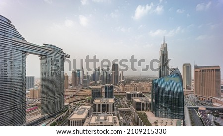 Futuristic Dubai Downtown and finansial district panoramic skyline aerial day to night transition timelapse. Many illuminated towers and skyscrapers with traffic on streets