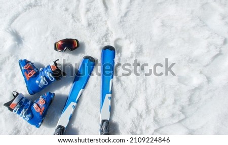 Mountain skis, sunscreen mask, ski goggles and ski boots on bright alpine snow. Winter holidays. Vacation, travel content. Copy space