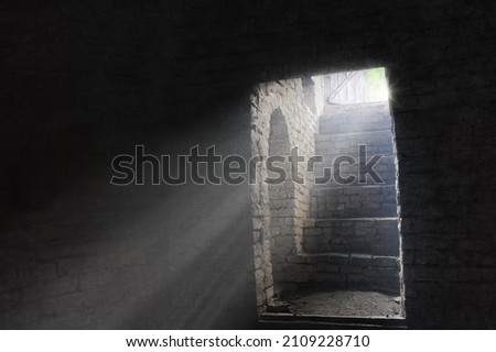 A picture of an old gloomy dungeon lightened by the rays of light through the open door - conceptual image for freedom, imprisonment, liberation etc.