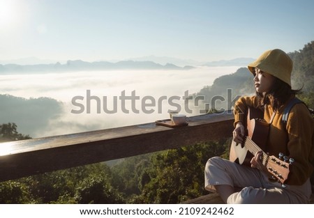 Asian traveller with camera take photo for a fog on a mountain at Japo village with a set of coffee and tea, mae hong son, Thailand