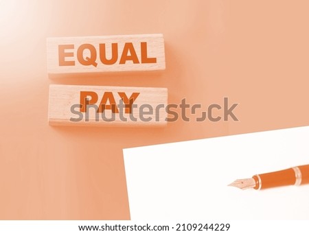 Equal pay words on wooden blocks. Income differences between men and women concept.